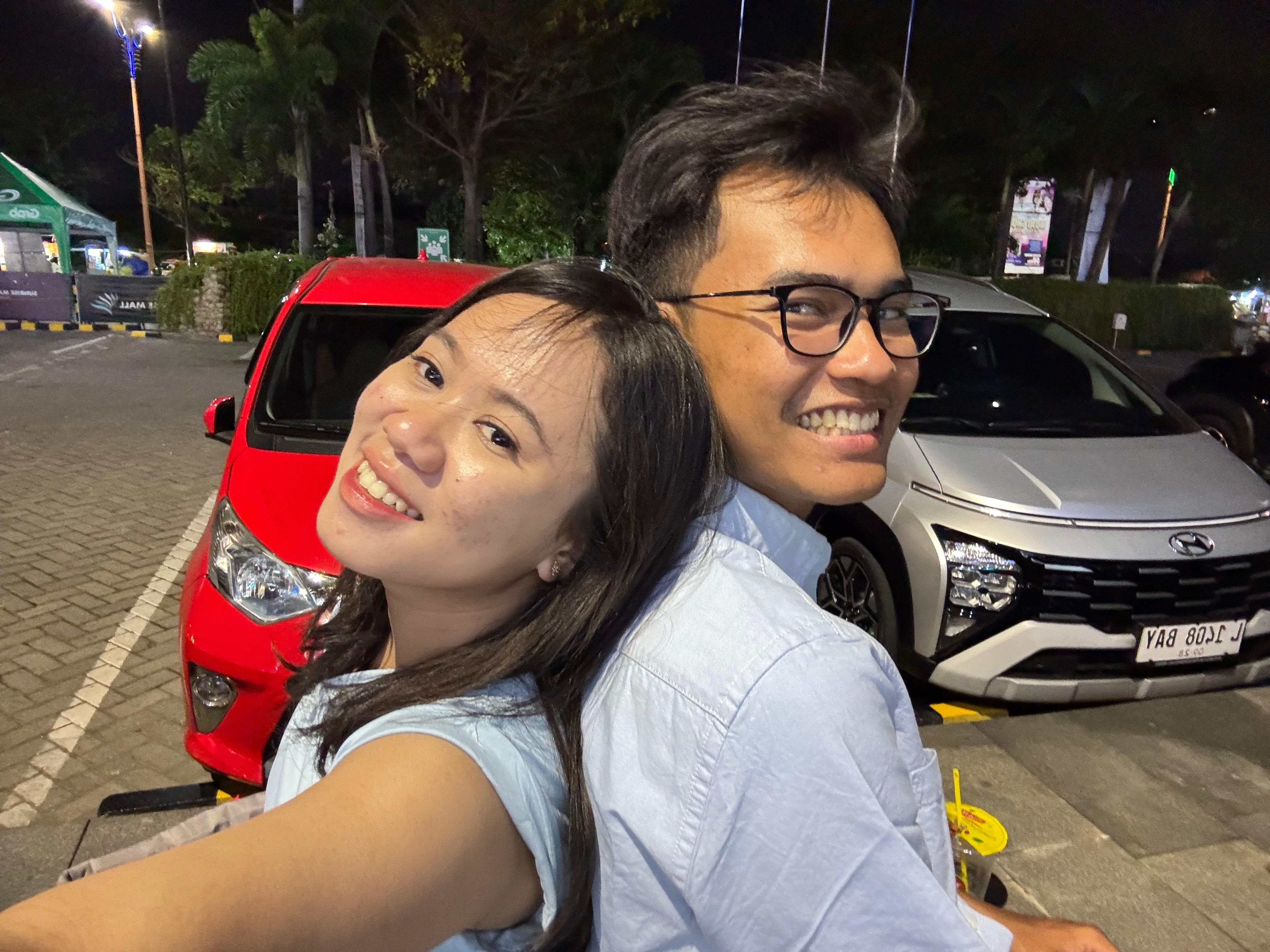 Adit dan Maylian tersenyum bersama di area parkir