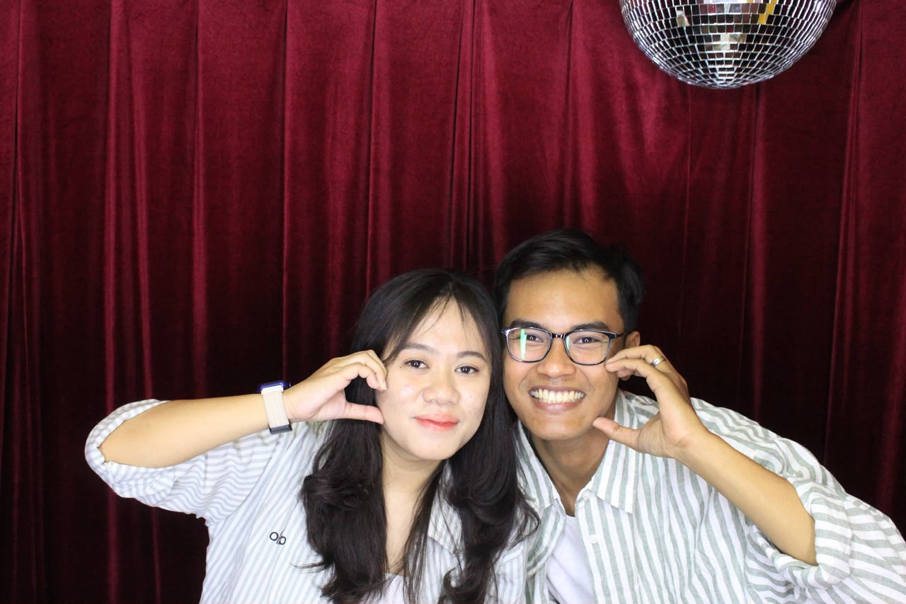 Adit dan Maylian tersenyum bersama di depan tirai merah